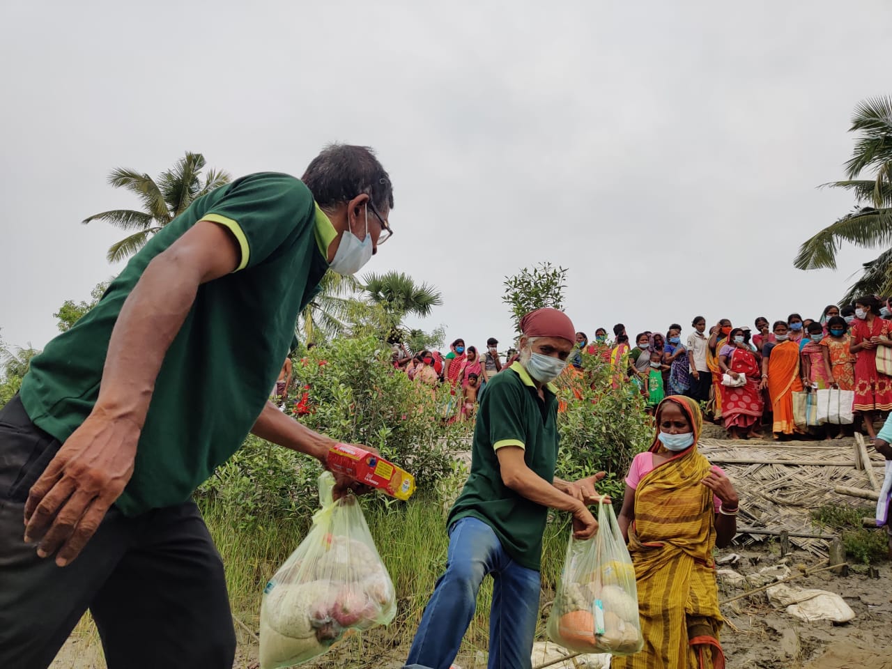 Hindol volunteer handing supplies to a woman in a rural area